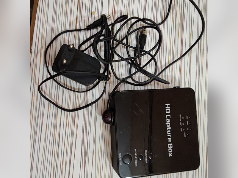 HD Capture Box, top view with power adapter and cables